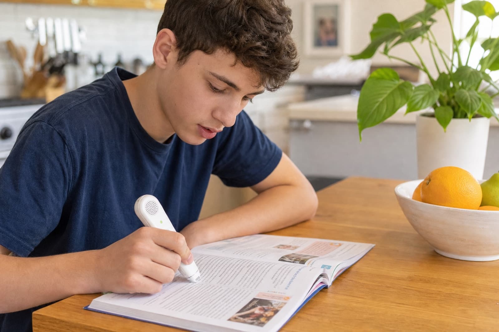 Teenager reading a textbook aloud with a scanning reading pen