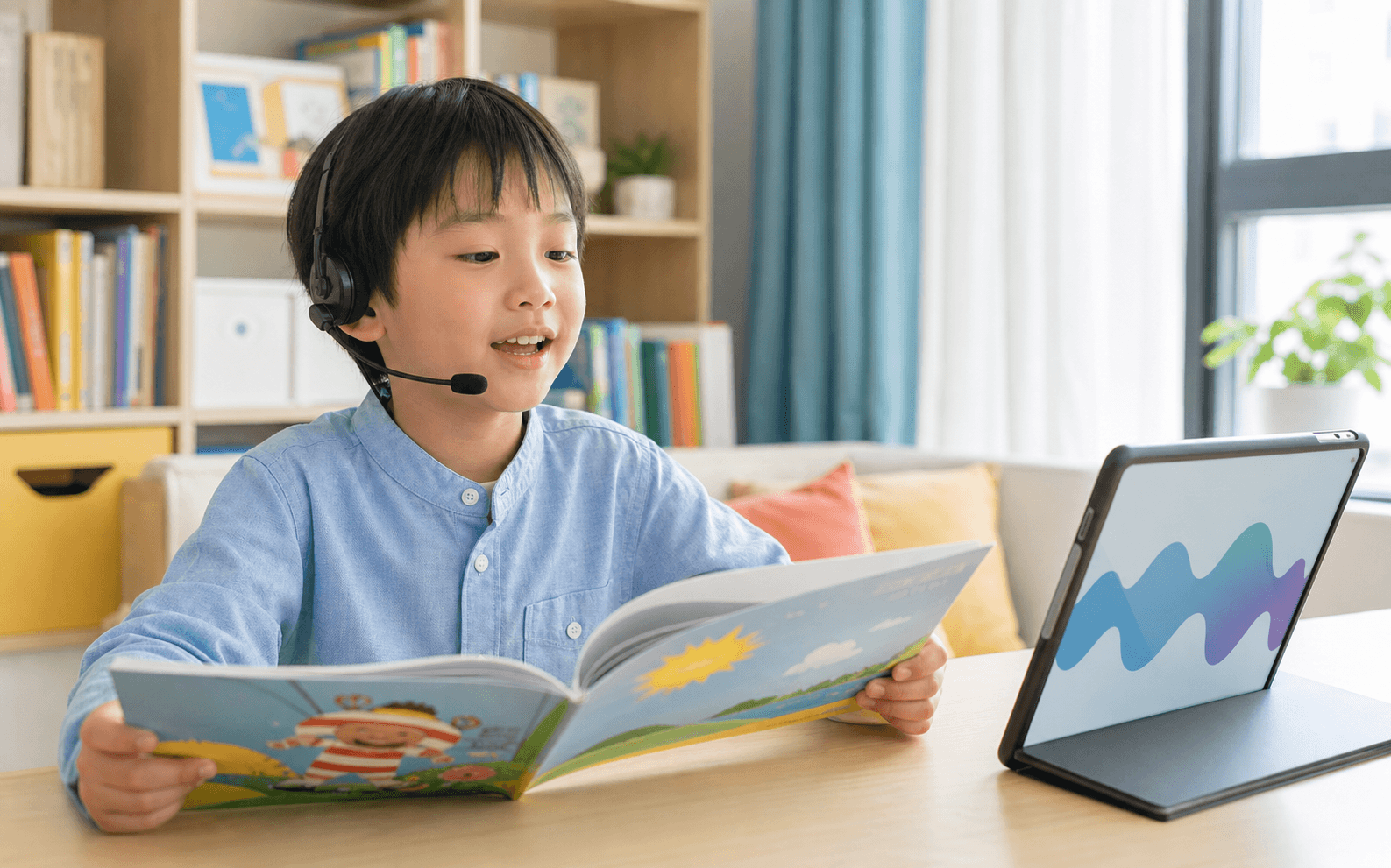 Young learner reading a picture book aloud while a tablet listens